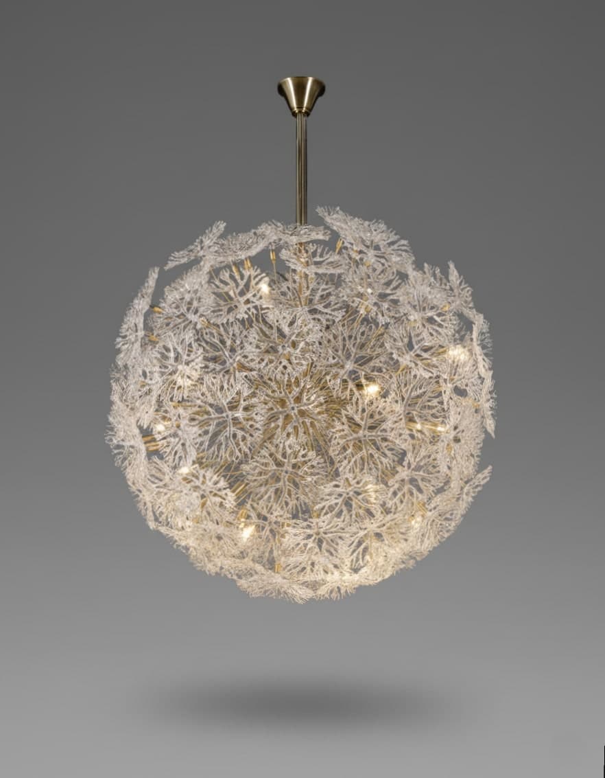 Luxury spherical chandelier with intricate glass branches and brass stem, photographed against a seamless grey background